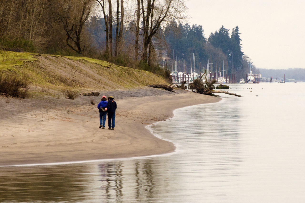 A couple walking the sandy beach near the end of Sauvie Island